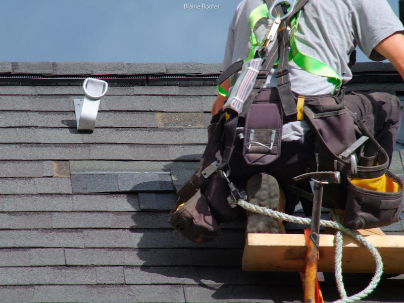 Roofer wearing safety harness and tool belt working on a shingled roof.